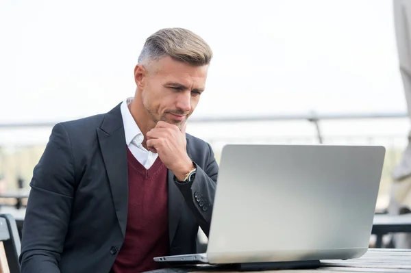 Bonito homem de negócios em estilo formal usar a tecnologia de computador para trabalhar online ao ar livre, e-business — Fotografia de Stock