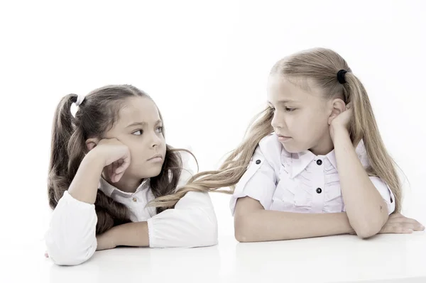 Adorabili studentesse. Torniamo a scuola. Concetto educativo. Belle ragazze migliori amiche. Stile formale. Buona infanzia. Le studentesse siedono alla scrivania sfondo bianco. Studentesse amici emotivi — Foto Stock