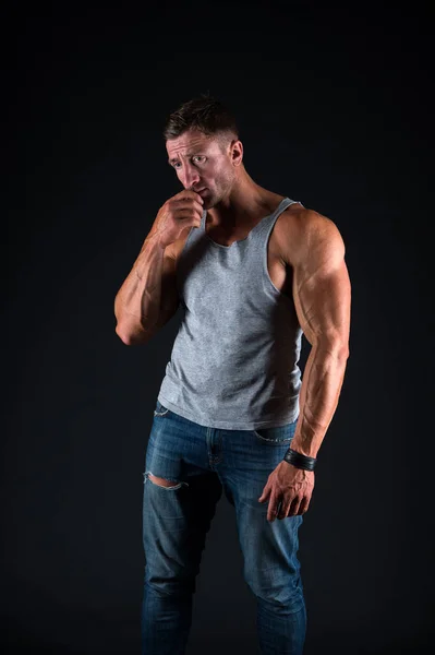 Nieszczęśliwy kulturysta nosić casual undershirt z dżinsy pokazując silne ramiona mięśniowe biceps triceps mięśni czarne tło, kulturystyka — Zdjęcie stockowe