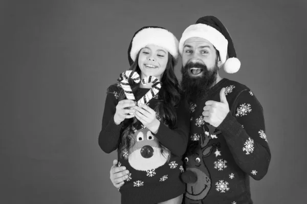 クリスマスキャロル。お父さんと娘のお菓子の犬のクリスマスの装飾。家族の休日。サンタ・クラスの家族みたいに。髭を生やしたお父さんと陽気な女の子。優しさと善のためのクリスマスの時間 — ストック写真