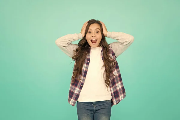 oh my god. child wear trendy casual jacket. kid spring and autumn fashion. little beauty. express positive emotions. happy small girl turquoise background. surprised schoolgirl has long curly hair
