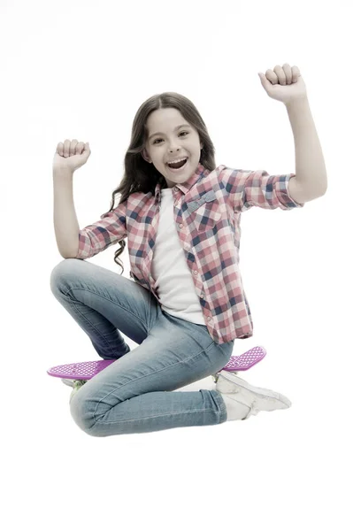 乗る時間だ。興奮した子供の女の子はペニーボードに座る。現代の十代の趣味。女の子幸せな顔ペニーボードの白い背景に座っている。もともと女の子スケートボードとして設計された。ペニーボードに乗る方法を学ぶ — ストック写真