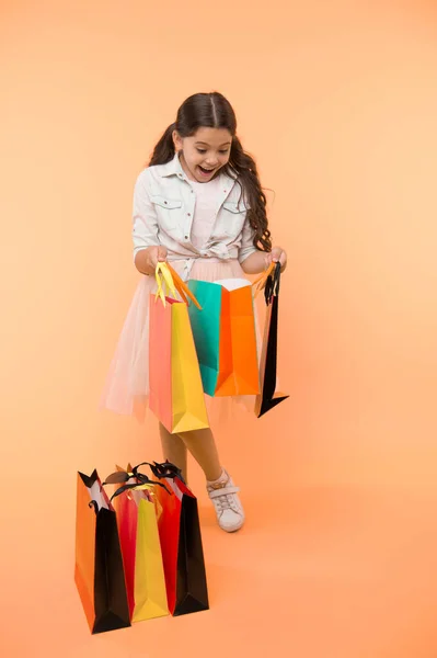Great strategies to save on back to school purchases. Back to school season teach budgeting basics. Girl carries shopping bags. Prepare for school season buy supplies stationery clothes in advance