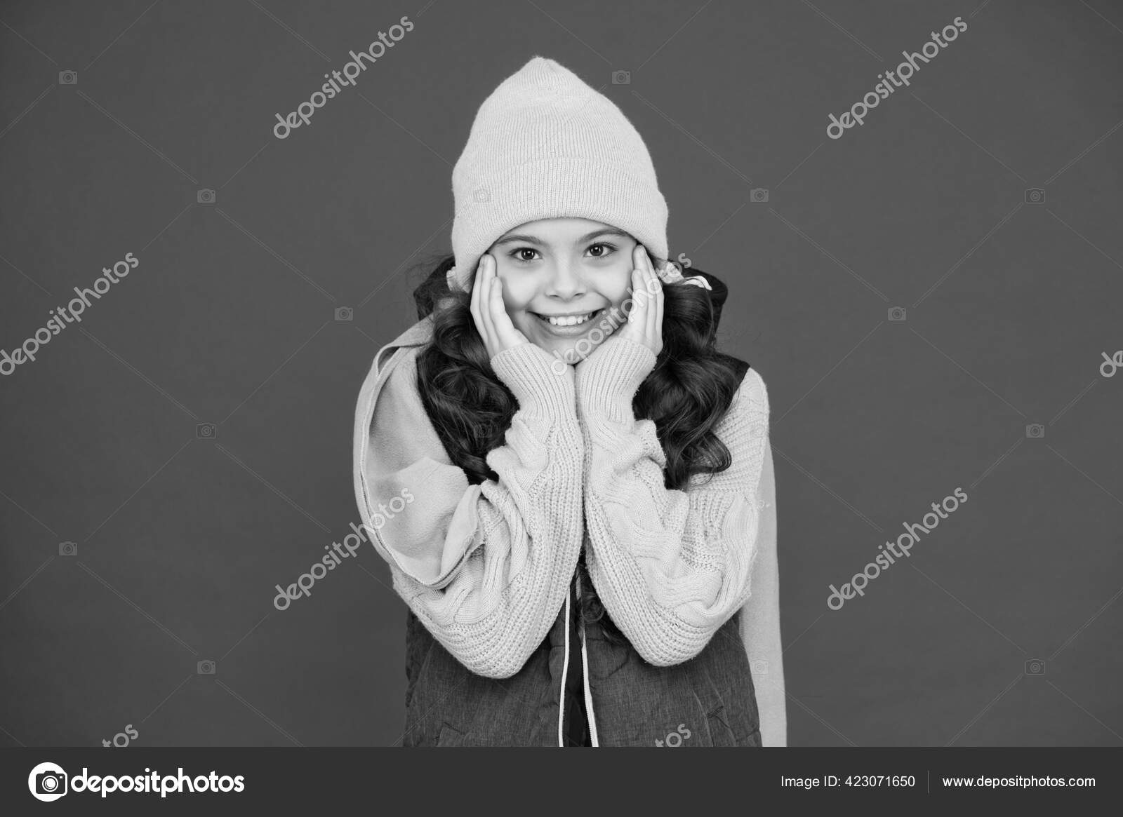 Small girl in knitted hat. looking stylish and cosy. its cold season. winter  and autumn weather forecast. wear warm clothes when its cold. fashion for  kids. childhood happiness. happy child smiling Stock