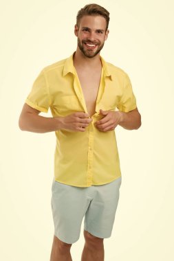 Gömleğinin düğmelerini ilikliyor. Erkek güzeli, manken. Saç şekillendirme konsepti. Günlük yaşamda sıradan bir tarz. İyi giyimli adam. Seksi model pozu. Yakışıklı bir adamın portresi. Mutlu seksi adam gömleğini ilikle