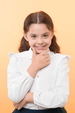 O bir eşek şakası planlıyor. Kız okul üniforması kurnaz yüzlü sarı arka plan. Kız okula mutlu döndü. Okulun sonuna hazır çocuk eğlenmeye devam ediyor. Liseli kız resmi kıyafeti çok şirin görünüyor.