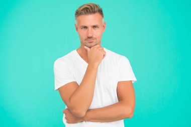 Son moda saç stili ile gülümseyen adam gri saçlı ve turkuaz arka planda bakımlı bir yüze sahip, kuaför