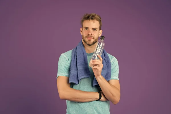 De l'eau dans le corps. Homme de sport tenant bouteille avec de l'eau. beauté et santé. Bouteille avec de l'eau pour le sport et l'entraînement. pour la protection contre la déshydratation. admission de liquide. le corps métabolise les nutriments — Photo