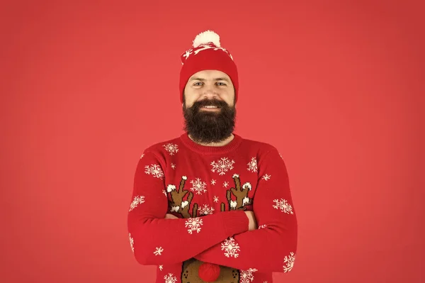 Téli bakancslista. Hipster szakállas férfi visel téli pulóver és kalap piros háttér. Boldog új évet! Csatlakozz ünnepi bulihoz. Karácsonyi pulcsi parti. Téli ruha. Jó kisugárzás. Divatüzlet — Stock Fotó