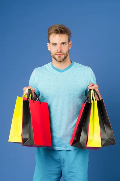 Capturar oportunidade. O homem barbudo tem sacos de compras. O tipo comprou roupas e acessórios desportivos. Homem às compras na sexta-feira negra. O tipo comprou muitos itens com desconto. Conceito de venda sazonal — Fotografia de Stock