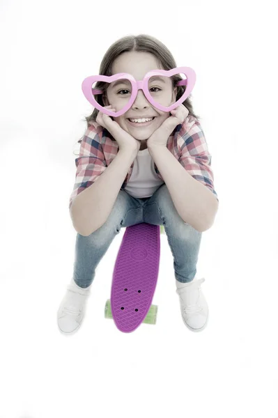ハート型のメガネの子供はスケートボードが好きです。楽しさと幸せ。ペニーボードとキッズガールカジュアルなスタイルは子供時代をお楽しみください。スケートボードで幸せな女の子は白い隔離された。趣味のレジャーコンセプト — ストック写真