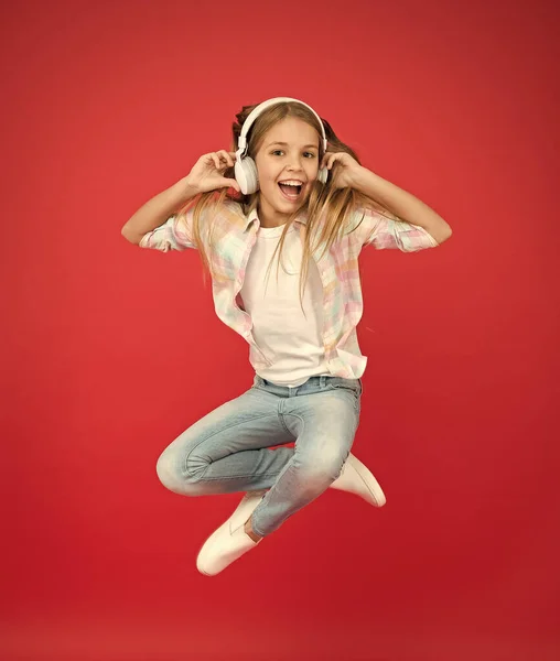 Nie endende Freude. Ich glaube, ich kann fliegen. Mädchen hören Musik modernes Gadget. Kind glücklich mit drahtlosem Headset tanzen Springen. Stereo Kopfhörer. Kind mit moderner Technologie. Modernes Kind. Perfekter Klang — Stockfoto