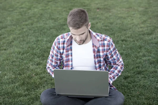 Millennial iş yaratıyor. Modern iş. Modern teknolojiler. Öğrenci çayır üzerinde çalışıyor. Çevrimiçi iletişim. İnternette sörf yapmak. Dizüstü bilgisayara bakan adam. Yetenekli geliştirici. Girişim — Stok fotoğraf