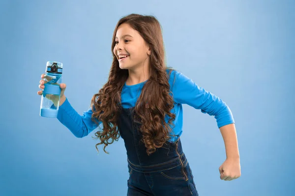 Πιες μερικά υγρά. Ζώντας υγιή ζωή. Υγεία και ισορροπία νερού. Κορίτσι κρατήσει μπουκάλι νερό μπλε φόντο. Το κορίτσι με τα μακριά μαλλιά έχει μπουκάλι με νερό. Έννοια ισοζυγίου νερού. Δυνατό και υγιές παιδί — Φωτογραφία Αρχείου
