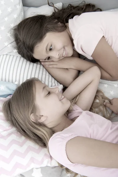 Condividere segreti. Bambini che si rilassano sul letto. Sorelle che preparano il sonno. Bella serata. Migliori amiche. Amici bambini. Affascinanti bambini carini hanno tempo libero prima di dormire. Dialogo migliori amici. Concetto di sorellanza — Foto Stock