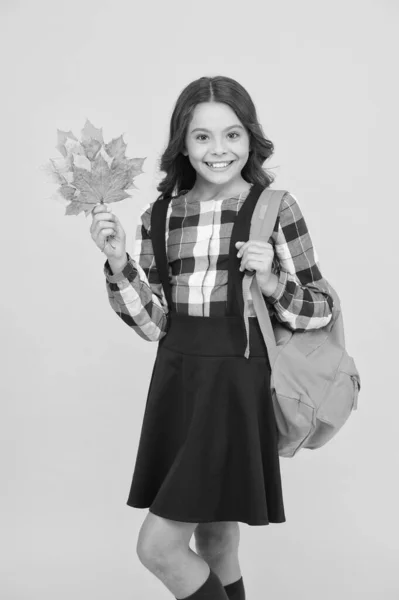 Sonbahar okul zamanıdır. Sarı arka planda mutlu liseli kız. Sonbahar yaprakları ve okul çantasıyla gülümseyen küçük bir çocuk. Küçük çocuk sonbaharda okula geri dönüyor. Ciddi değil, sadece okul mutluluğu. — Stok fotoğraf