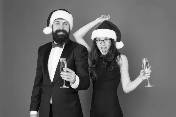 Šťastný Nový rok. Veselé Vánoce. obchodní pár pije šampaňské. Vánoční večírek. milují nový rok. zdravím koncept. slavnostní párová hostina. smoking muž s ženou v santa klobouku — Stock fotografie