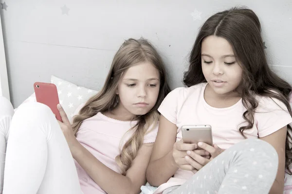 Móvil adicto. Chica jugar juegos de teléfono inteligente en línea. Concepto de fiesta de pijamas. Feliz infancia. Niños navegando por internet aplicación móvil redes sociales. Niños modernos que viven la vida en línea teléfonos móviles — Foto de Stock