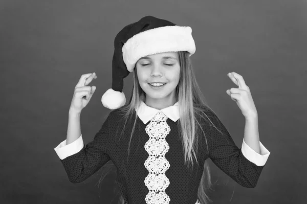 Kerstmeisje mediteert. Ontspan en glimlach. kind santa rode achtergrond. Het is kerst. Gelukkig nieuwjaar. Ik wacht op het kerstfeest. Doe een wens. Dromen komen uit. meditatiegebaar. winteryoga — Stockfoto