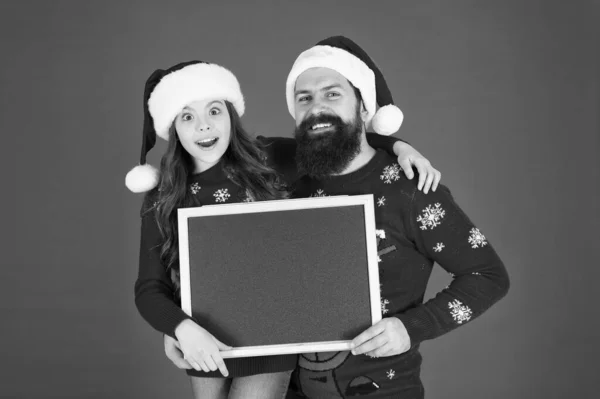 Winter sale. Shopping sale season. Seasonal sale. Christmas discount. Happy hours concept. Santa claus. Dad and small girl showing chalkboard. Christmas wishes. Father daughter blackboard copy space