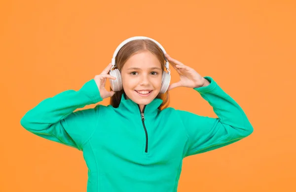 Staw czoła muzyce. Małe dziecko słucha muzyki żółtego tła. Małe dziecko lubi muzykę grającą w słuchawkach. Jak muzyka dla moich uszu. — Zdjęcie stockowe