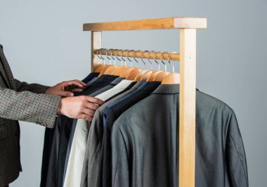 Demiryolu butik müşteri seçen takım elbiseli ceketler, renk çeşitliliği konsepti.