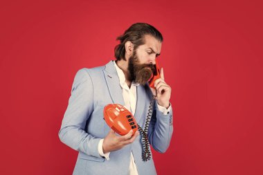 Şimdi beni duyabiliyor musun? Retro telefonu olan ciddi bir adam. Vahşi sakallı adam klasik telefon tutuyor. Modern hayatta teknoloji kavramı. İletişim. Sohbet etme fikri. Adam telefonda konuşuyor.
