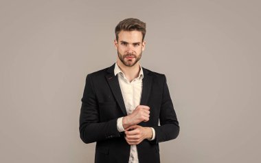Kendine güveni tam. Gri arka planda bir iş adamının portresi. Kendine güvenen iş adamı portresi. Yakışıklı bir CEO portresi. Takım elbiseli bir iş adamı. Genç yakışıklı adam. Genç müdür ofisinde.