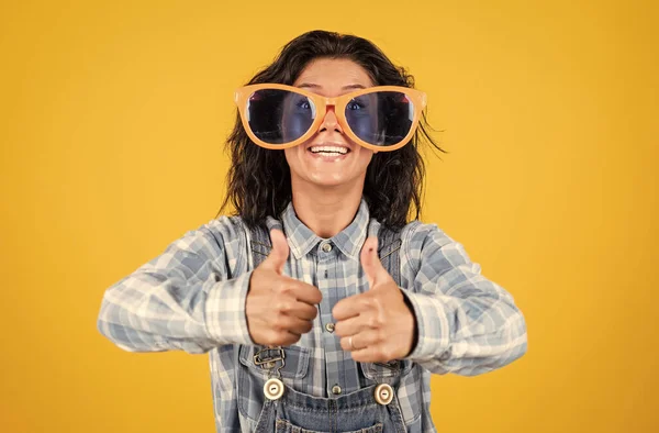 Il giorno migliore. concetto di vita spensierata. stile di vita hipster. donna felice in stile denim. divertente hipster ragazza in occhiali da festa. donna che indossa una camicia a scacchi con il pollice in su. bellezza femminile e moda — Foto Stock