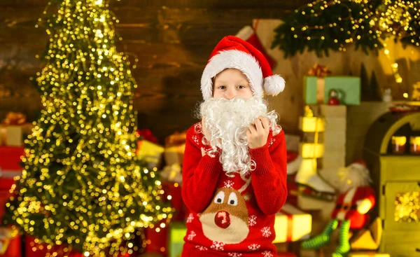 最高の願いだ。サンタさんの帽子とセーター。クリスマスの冬だ。贈り物やプレゼントを買う。季節の買い物。新年のパーティーの準備ができている小さな男の子。幸せな子供は家でクリスマスを祝う — ストック写真