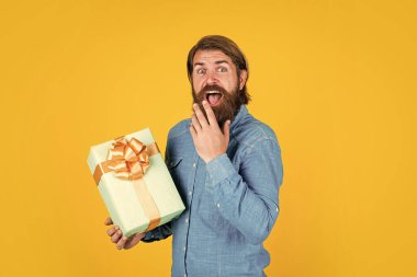 Dükkandan alışveriş yapıyor. Yıldönümü hediyesi al. Şaşırmış erkek kutusu içinde heyecan verici bir şey var. Olgun bir adam hediye kutusuyla şaşırmış görünüyor. Genellikle doğum günlerinde kullanılır.