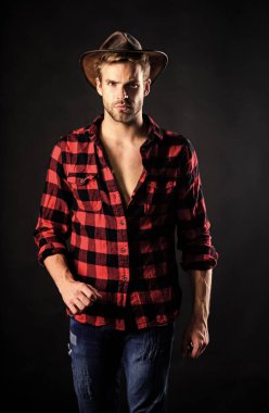 Masculine ideal. Western life. Masculinity and brutality concept. Cowboy life came to be highly romanticized. Adopt cowboy mannerisms as a fashion pose. Man unshaven cowboy black background clipart