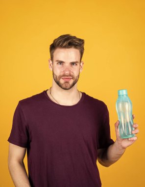 Detoksifikasyon. Yakışıklı adam su şişesini tutuyor. Susuzluk ve su dengesi. Spor ve sağlık. Formdayken ferahlatıcı. Vücuttaki su dengesi. Sağlık sigortası. Adam aktif eğitimden sonra su içiyor