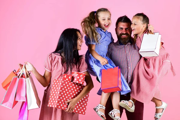 Vente, consumérisme et concept de personnes. parents et leurs filles tiennent des sacs en papier. équipe de clients de la famille. week-end shopping. vacances. famille heureuse avec des sacs à provisions. Bel achat — Photo