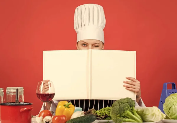 Kadın şef yemek hazırlıyor. Mutfakta yemek pişirmek. Sağlıklı yemek pişirmek için açık tarif kitabı. Malzemeler hakkında bir sır saklıyor. Kadınlar yemek kitabı kullanır. Profesyonel şef yemek tarifi okur. Boşluğu kopyala — Stok fotoğraf
