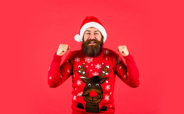 Úspěšný a šťastný. Šťastný nový rok. Veselé Vánoce. muž s plnovousem na červeném pozadí. Vánoční nákupy. zralý hipster nosí pletený svetr. brutální vousatý muž v klobouku Santa Clause — Stock fotografie