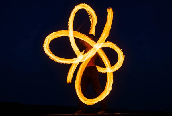 Artista de fuego individual realizar espirales infinitas girando pois llameante en el cielo oscuro en la noche al aire libre, llama —  Fotos de Stock