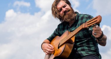 Bıyıklı ve sakallı vahşi adam gitar tutuyor. Müzik dükkanı. Sakallı adam bir rock yıldızı. Sıradan bir erkek gitarist. Müzik ve vokal konsepti. Akustik gitar çalan bir adam. Boşluğu kopyala
