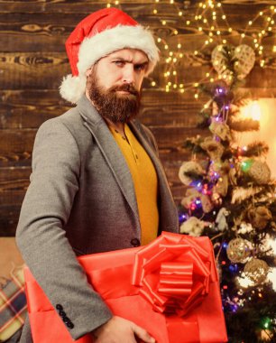 Noel ruhu burada. Mutluluk ve neşe saçın. Sakallı adam Noel Baba şapkası takıyor ve hediye kutusu taşıyor. Teslimat, yılbaşı hediyesi. Teslimat servisi. Noel hediyesi. Erkek Noel Baba 'nın hediyesi.