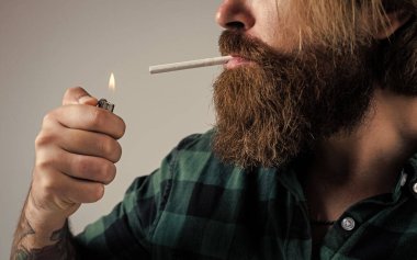 Sigarayı yak. Sakallı adam. Sigara içme alışkanlığı. Bıyıklı vahşi hippi. Günlük giysiler içinde manken. Erkek güzellik standardı. Çok modaya uygun görünüyorsun. Kendine güvenen ve yakışıklı vahşi bir adam.