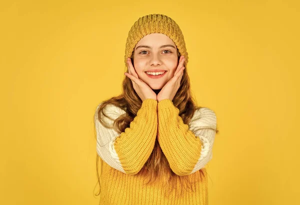 쾌활 한 어린이는 모자를 쓰고 좋아 하는 스웨터를 입는다. 어린 시절의 행복. 노란 배경의 10 대 소녀. 뜨개 질하는 여자 애. 아이들의 미와 패션. 겨울에는 따뜻 해집니다. 추운 일기 예보 — 스톡 사진