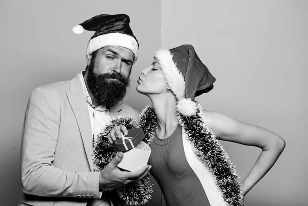 Vánoční večírek v kanceláři. Šťastný muž a žena nosí Santovy klobouky. Veselý pár slaví nový rok. Kancelář vánoční párty. Dávám dárek. Slavnostní nálada. Boxerský den. Tajný Santa. Zimní firemní večírek — Stock fotografie