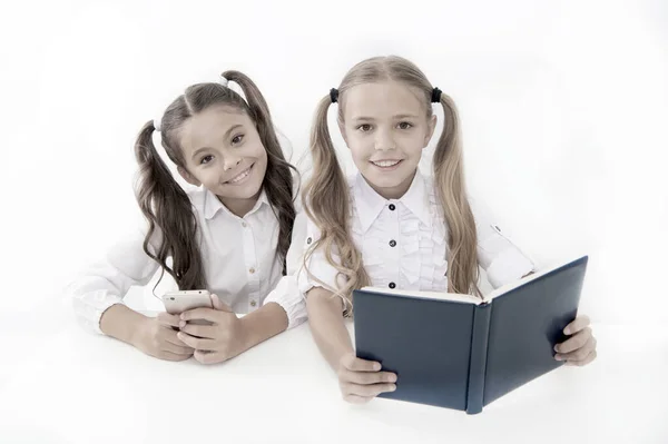 Bilgi topluyorum. Modern veri depolama yerine büyük kağıt kitap. Küçük kızlar kağıt kitap ve kitap okuyor. Akıllı telefon. Eğitim başvurusu. Eğitici uygulama cep telefonu. Eğitim çevrimiçi — Stok fotoğraf
