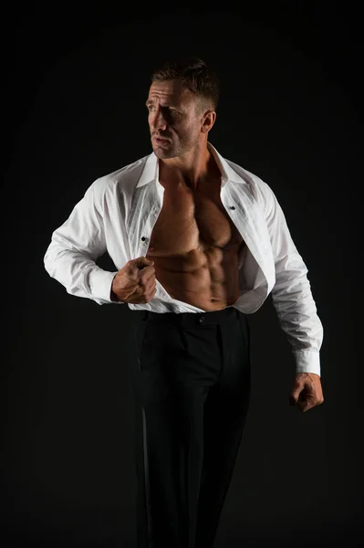 Muskularny mężczyzna pokazać pasuje tułów z sześciopakiem abs w otwartej koszuli formalny styl czarny tło, sześciopak — Zdjęcie stockowe
