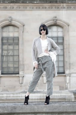 Yüksek topuklu ayakkabılı, şık elbiseli bir model.