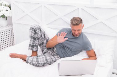 Seni gördüğüme sevindim. Görüntülü arama. Evden çalışıyorum. Olgun erkek pijamaları. Bilgisayarlı bir iş adamı. Hippi bilgisayarı çalışıyor. Yatak odası yeni ofis oldu. Uzaktan kumanda. İnternetten alışveriş. Çevrimiçi iletişim