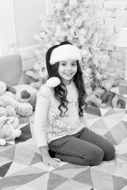 Mutlu yıllar. İstek listesi olup olmadığını sor. Küçük bir çocuk Noel Baba şapkası takıyor ve yeni yılı ev dekorasyonuyla kutluyor. Noel 'den önceki sabah. Yeni yıl tatili. Yatak odasında oyuncak taşıyan bir kız.