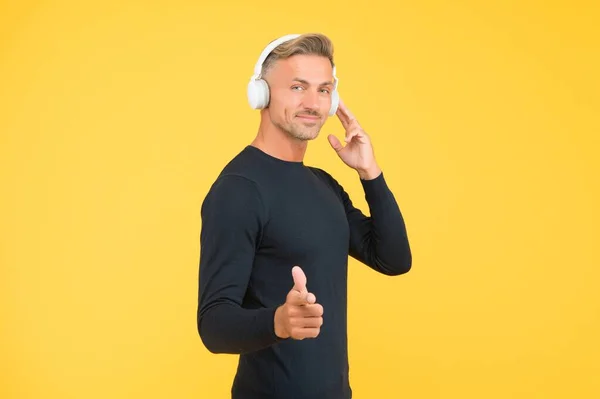 Stylish mature guy with trendy hairstyle wearing earphones listening ebook or audio book for study online, music lover — Stock Photo, Image