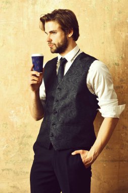 Takım elbiseli bir iş adamının elinde kahve kağıdı.