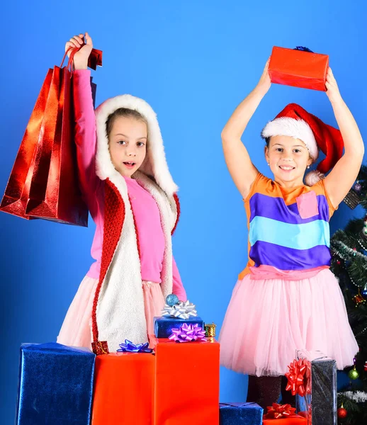 Niños en los sombreros de Santa Claus con cajas de regalo tienen regalos —  Fotos de Stock